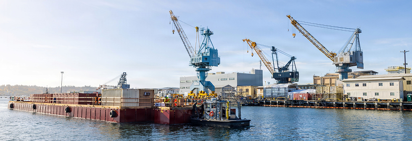 Side view of a shipyard with cranes.